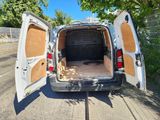une camionnette blanche dont les portes sont ouvertes dans la rue
