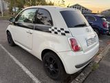 a small white car that is parked in a parking lot