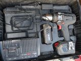 a box with a drill and two other tools in it