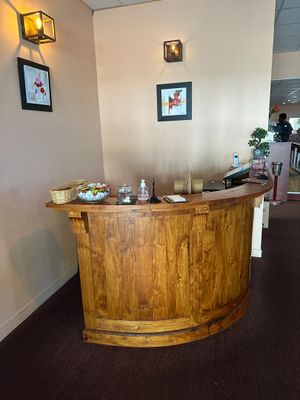un bar en bois au milieu d'une pièce avec des tableaux accrochés au mur
