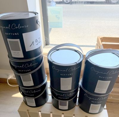 trois seaux de peinture posés sur une caisse en bois