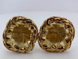a pair of gold toned earrings with a flower design