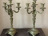 pair of antique brass candelabs on a marble table