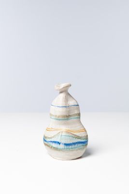 un petit vase blanc et bleu posé sur une table