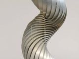a silver spiral lamp that is on a table