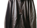 brown leather jacket hanging on a hanger on a white wall