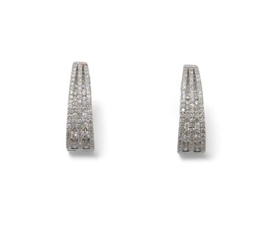 une paire de boucles d'oreilles créoles en diamant sur fond blanc