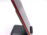 a red and black cell phone sitting on a stand