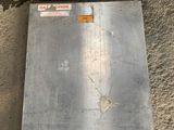 a metal box that is on the ground next to a wall