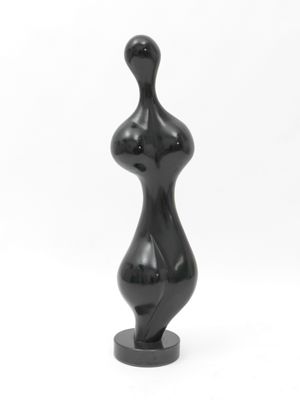black sculpture of a female torso on a black base on a white background