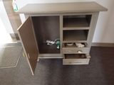 a small cabinet with a door open and a toothbrush in it