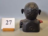 a small figurine of a person sitting next to a number 27
