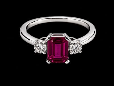 une bague sertie d'une émeraude et de diamants sur fond noir
