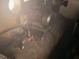 a small air compressor sitting in the corner of a room