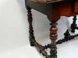 une vieille table en bois avec des pieds tournés et un plateau en bois