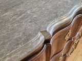a marble top on a wooden dresser in a room