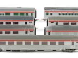 three silver and red train cars sitting next to each other on a white surface