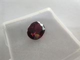 a close up of a red diamond on a white surface
