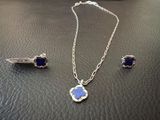 collier et boucles d'oreilles en argent ornés de pierres bleues sur un support en cuir