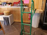 a green hand truck with a green handle in a room