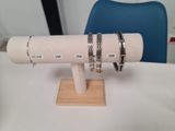 two bracelets that are on a stand on a table