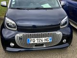 La Smart est garée sur un parking, à côté d'une voiture bleue