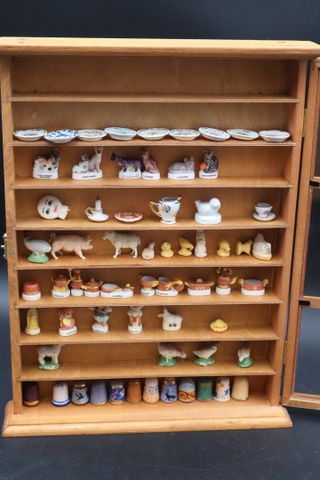 Collection de fèves, dés et petites assiettes dans une vitrine