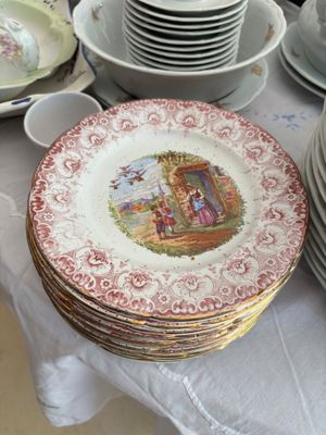 de nombreuses assiettes et tasses sur une table recouverte d'une nappe blanche
