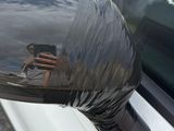 a reflection of a man in a mirror on the side mirror of a car