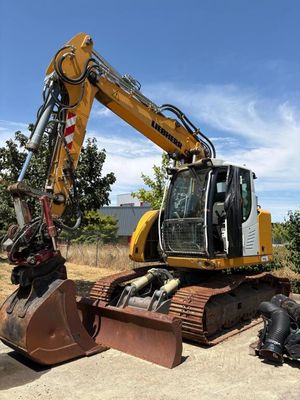 une pelleteuse jaune et noire qui est à l'arrêt dans la terre