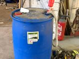 un fût bleu posé dans un garage à côté d'une poubelle bleue