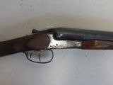 a close up of a gun with a wooden handle on a table