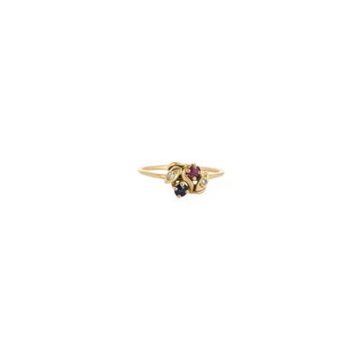 un gros plan d'une bague en or sertie d'une pierre rouge et d'une pierre bleue