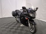 une moto noire garée sur un sol à damier