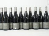 six bouteilles de vin sont alignées sur une table