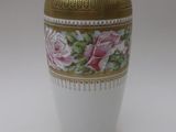 un vase blanc orné d'un liseré doré et de roses roses