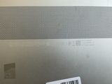 the back of a silver laptop with a barcode on it