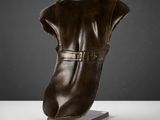 une photo d'une sculpture représentant une botte posée sur un socle en bois
