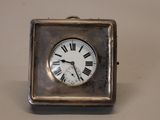 a silver clock with roman numerals on the face