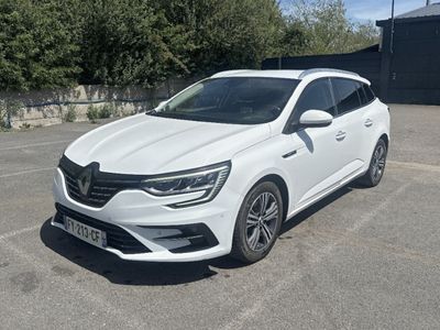 la voiture blanche est garée dans le parking à côté d'un bâtiment