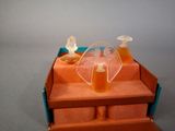 bottles of orange liquid in a blue box on a gray surface