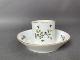 a close up of a cup and saucer on a table