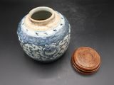 a blue and white vase with a wooden lid on a table
