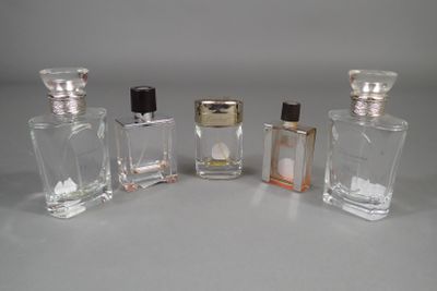 trois petits flacons de parfum posés l'un à côté de l'autre sur une table