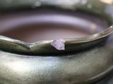 a close up of a bowl with a crystal on it