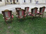 four chairs are sitting in the grass in front of a building