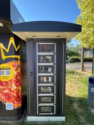 un distributeur automatique de pizzas sur lequel est posée une couronne