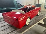 a red toy car sitting on top of a picnic table