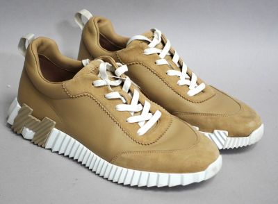 baskets beiges avec des lacets blancs sur une base grise