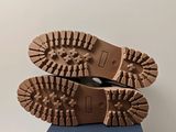 the soles of a pair of brown boots on top of a blue box